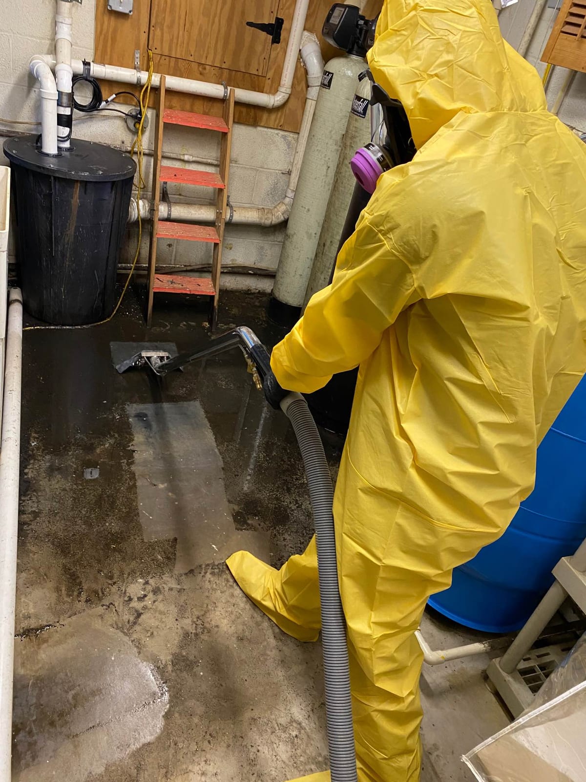 Clean Sweep technician in protective gear extracting water during a restoration job